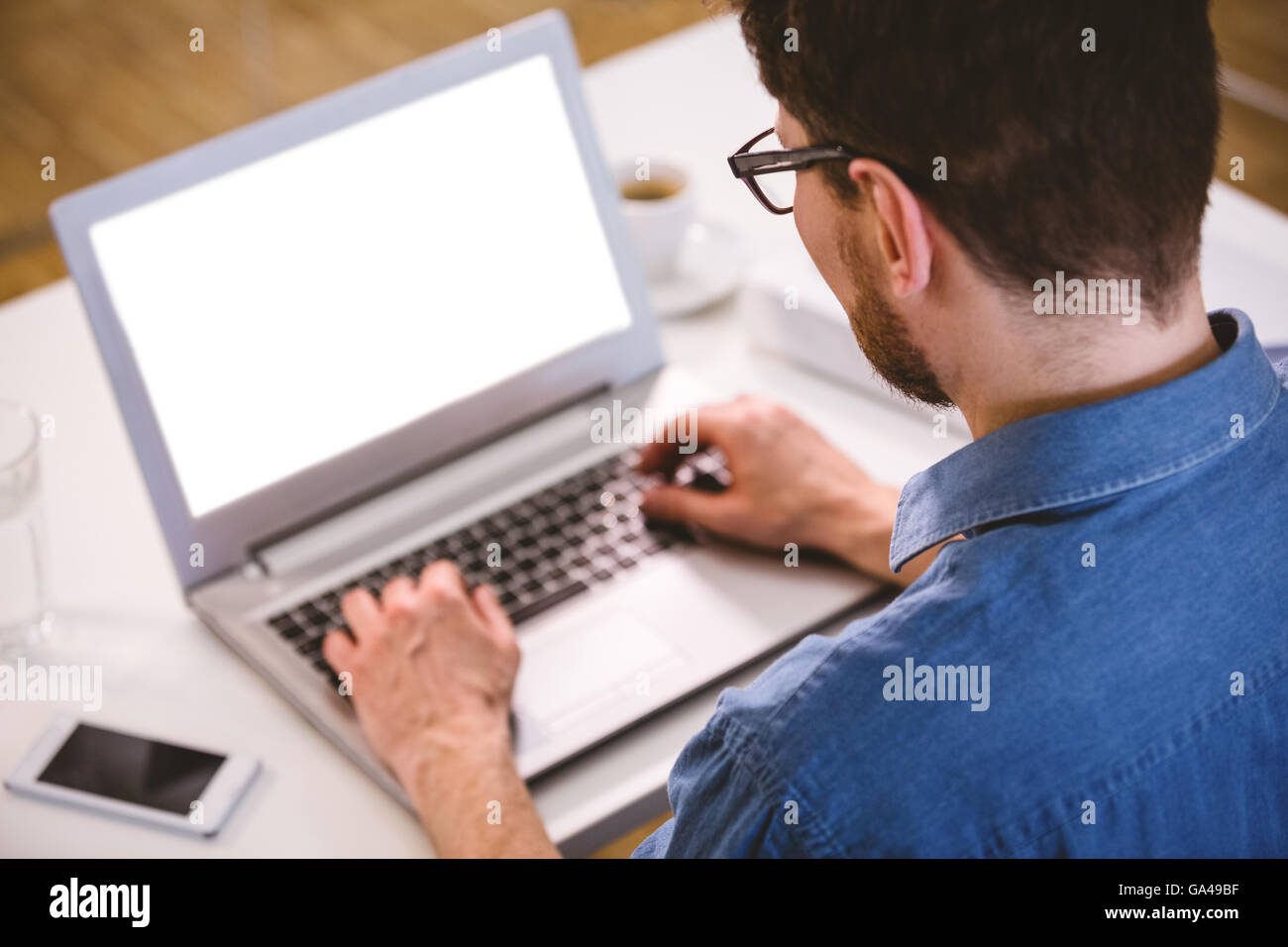 Rückansicht des executive Tippen auf Laptop im Kreativbüro Stockfoto