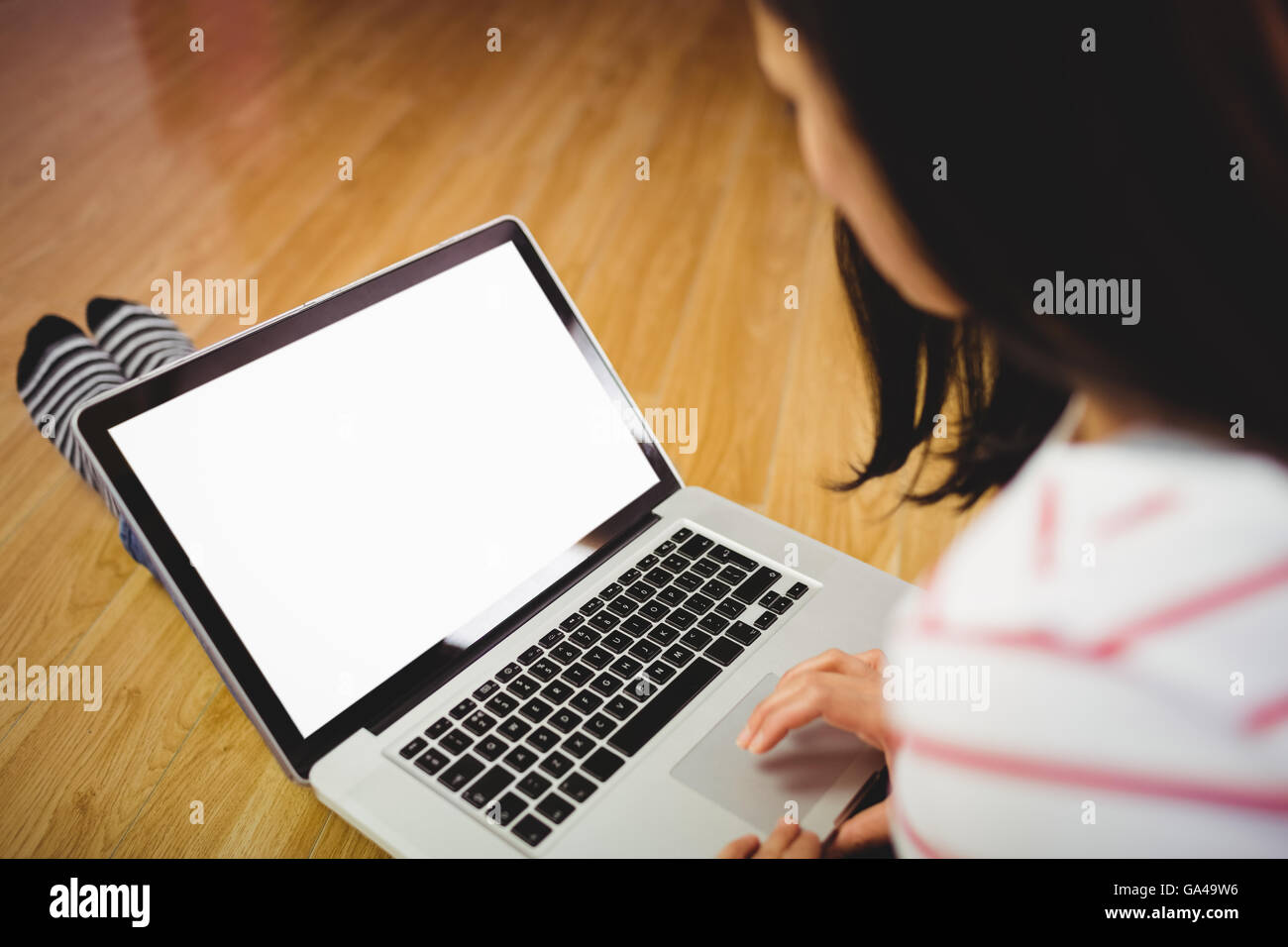 Frau mit Laptop auf Parkettboden Stockfoto