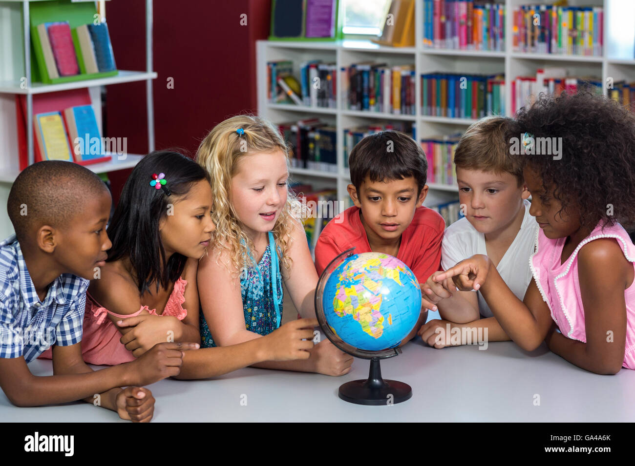 Kinder suchen im Globe auf Tisch Stockfoto