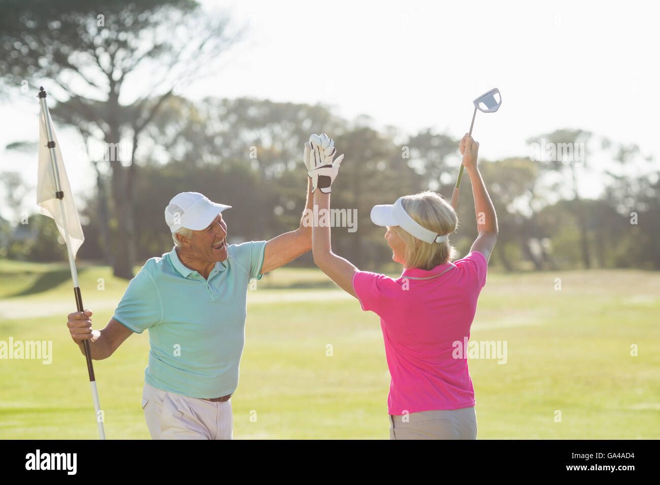 Fröhliche ältere Golfer paar geben hohe fünf Stockfoto