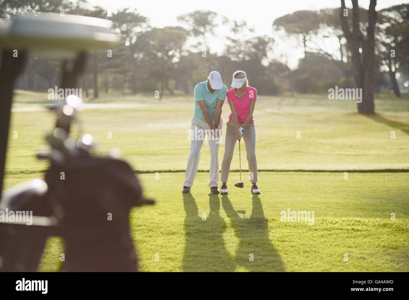 Voller Länge des Mannes unterrichtet Frau um Golf zu spielen Stockfoto