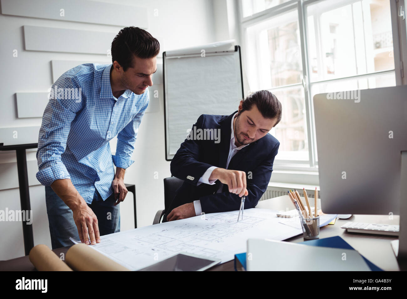 Innenarchitekt Blaupause mit männlichen Kollegen diskutieren Stockfoto