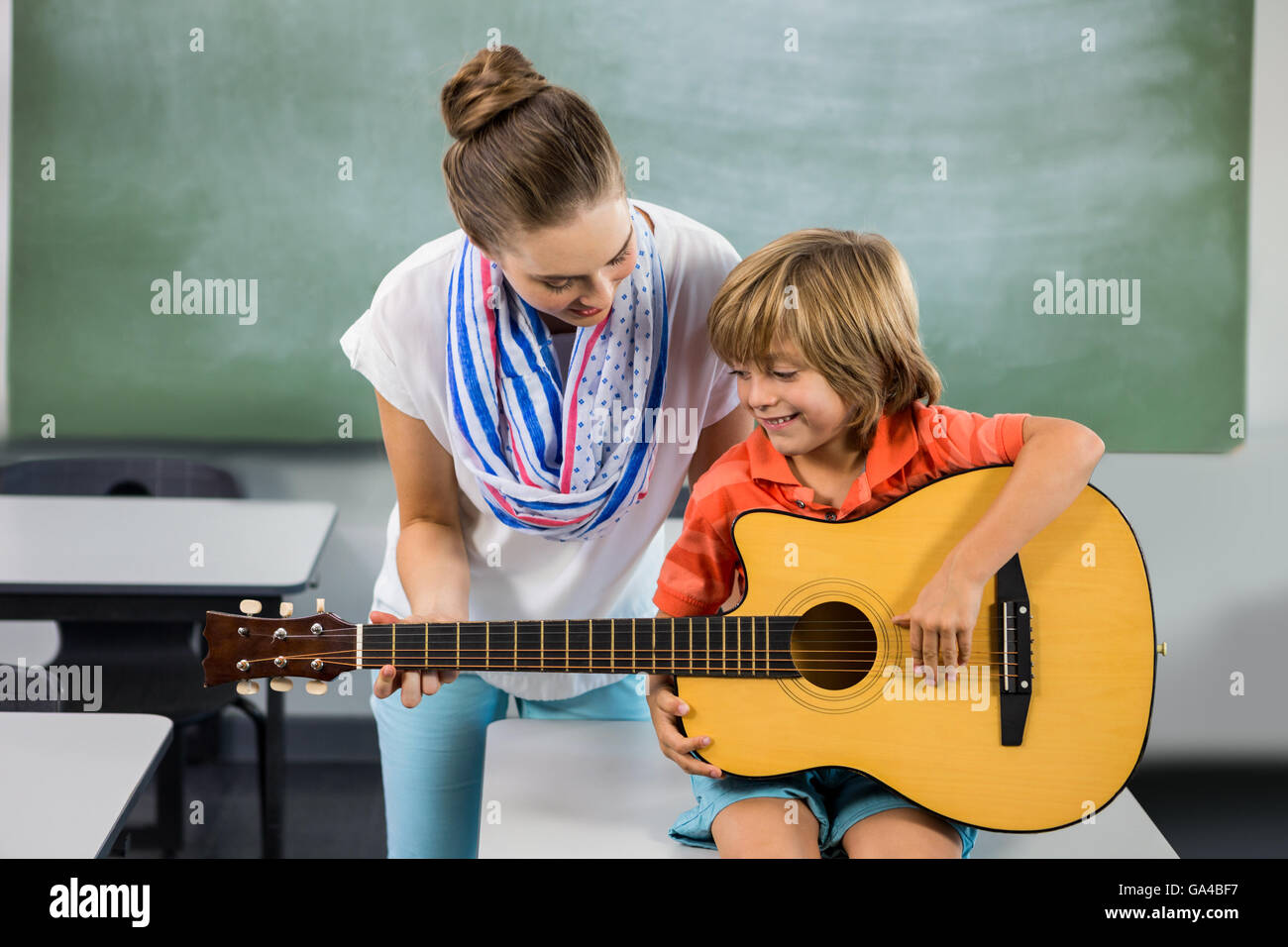 Lehrer, die Unterstützung der jungen, Gitarre zu spielen Stockfoto