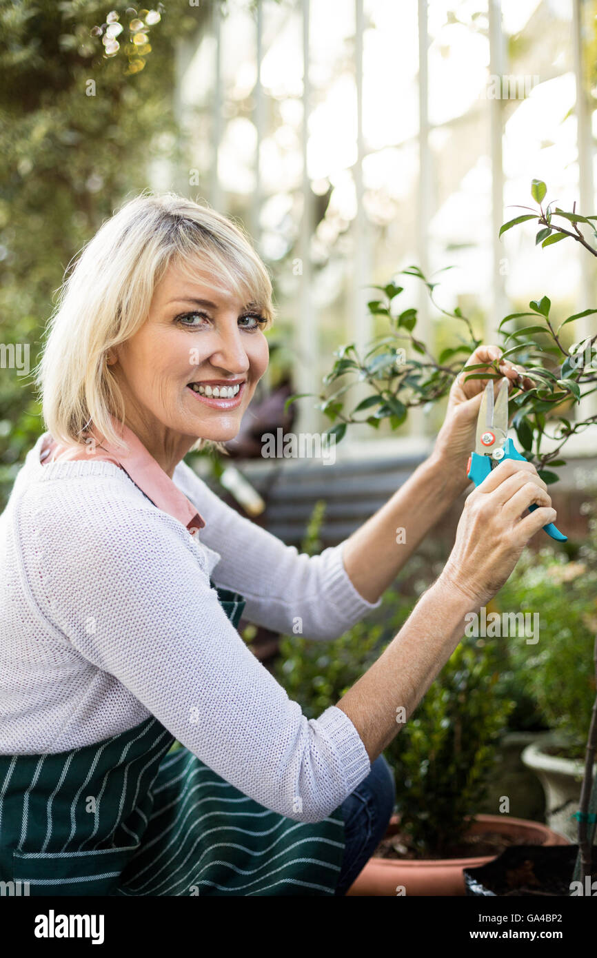 Porträt von weiblichen Gärtner beschneiden Pflanzen Stockfoto