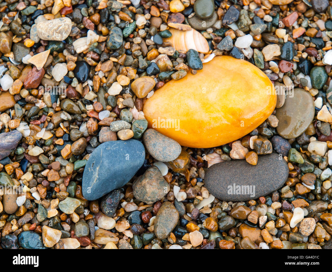 Gelbe Kiesel auf einem walisischen Strand Stockfoto