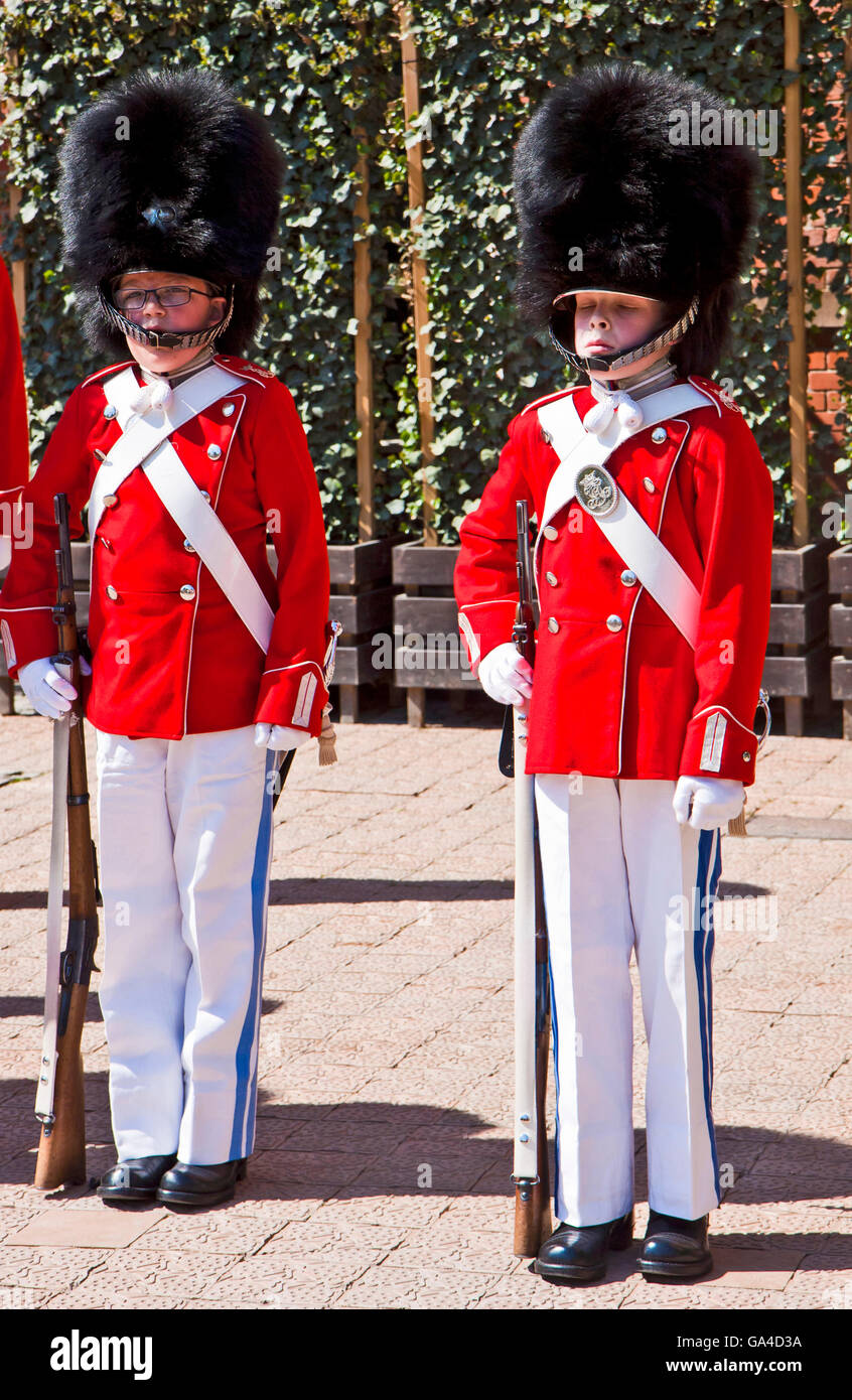 Kopenhagen, Dänemark - zwei jungen des Tivoli Jugend Gard durchführen in rot-weiße Uniform und Bärenfell Hut am Tivoli Gardens amusem Stockfoto