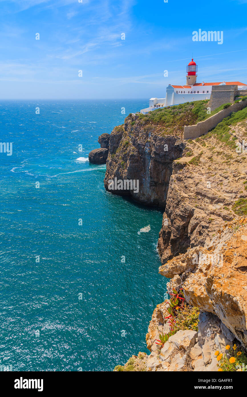 Blaues Meer und Leuchtturm auf Felsen am Region Cabo Sao Vicente, Algarve, Portugal Stockfoto