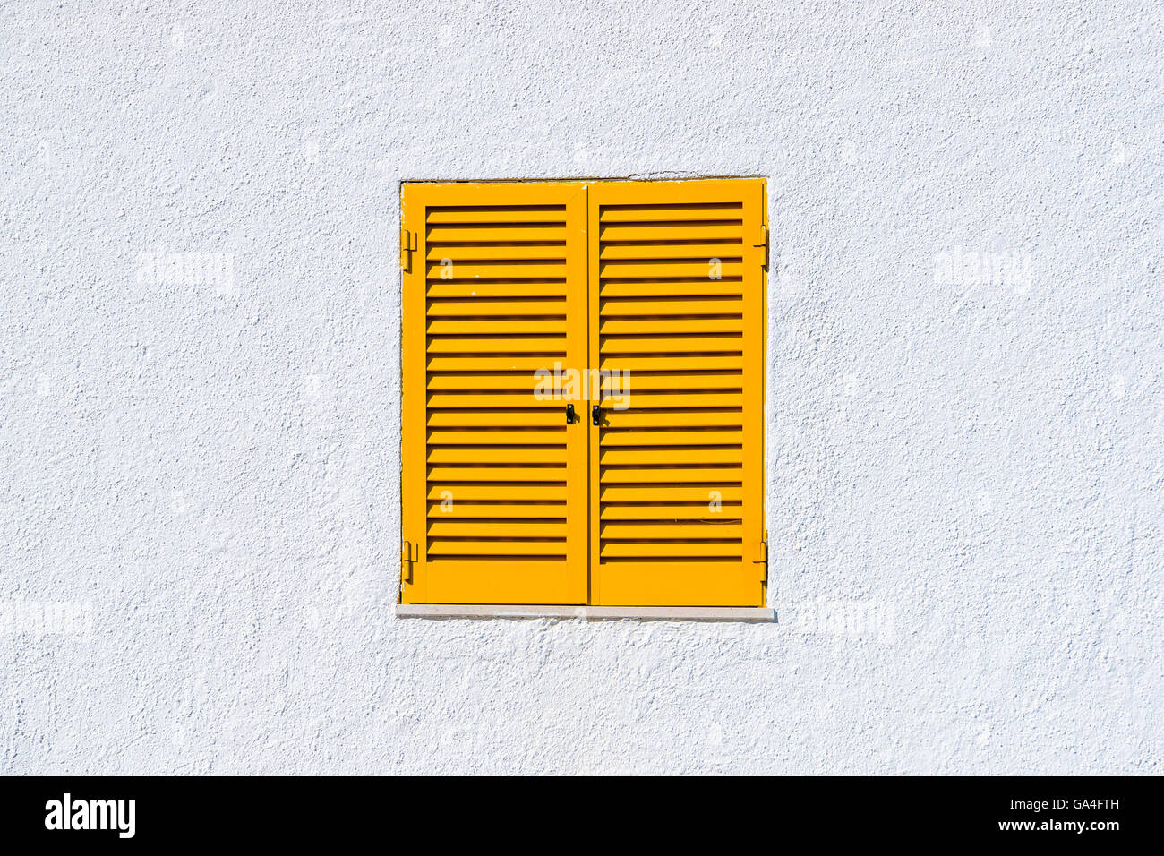 Gelben Fensterläden und weiße Wand eines Hauses in der Stadt Luz, Portugal Stockfoto