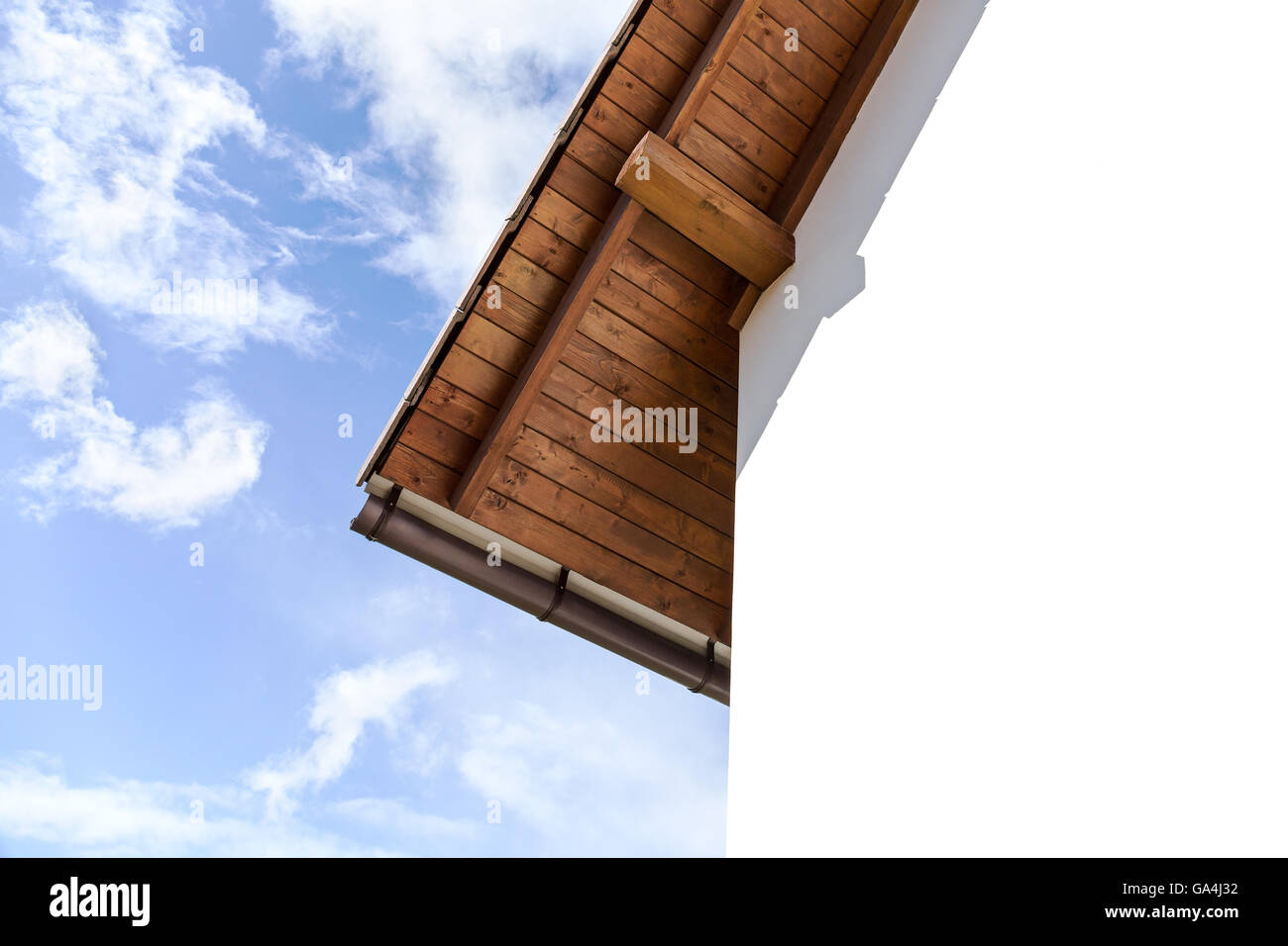 Dach mit Sparren und verputzte Wand des Hauses gegen bewölktem Himmel Stockfoto