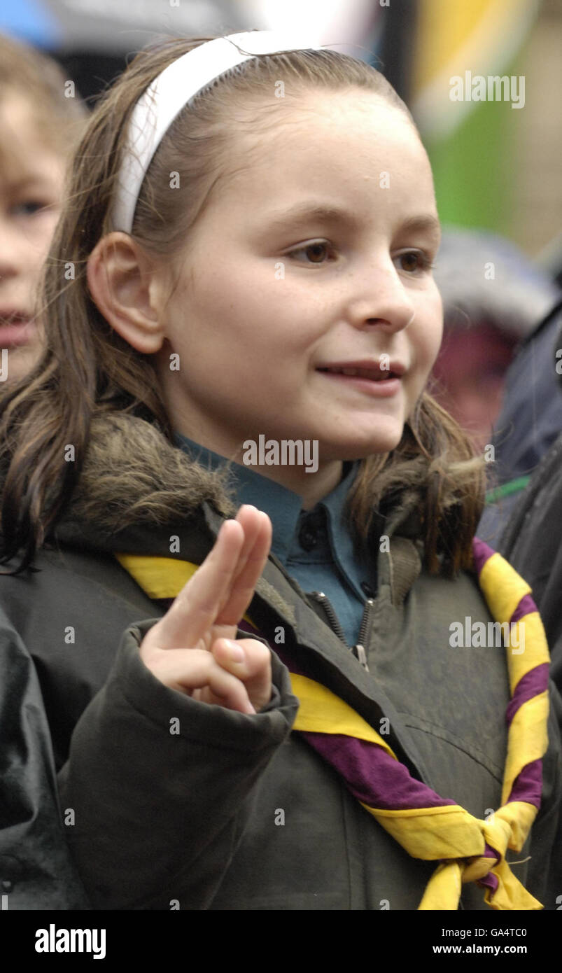 A Scout erneuert ihr Versprechen, vor der Teilnahme an einem Massen-Aerobic-Training in Glasgow George Square, zu verdienen Gedenkfeier Glasgow 2014 / Scouting Sunrise Abzeichen. Stockfoto