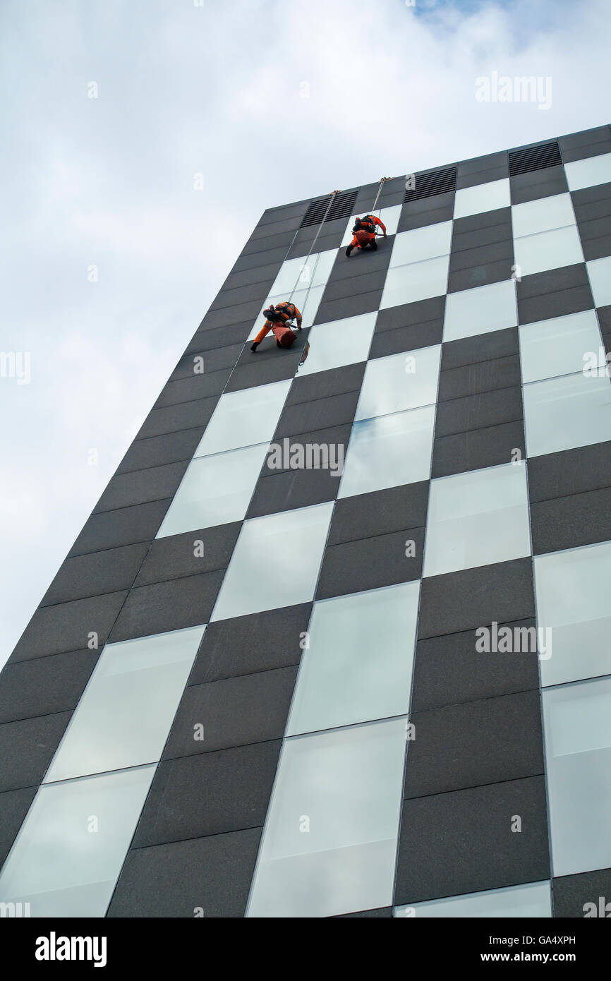 Hohe Niveau Fensterreinigung Glasreiniger auf Seilen Stockfoto