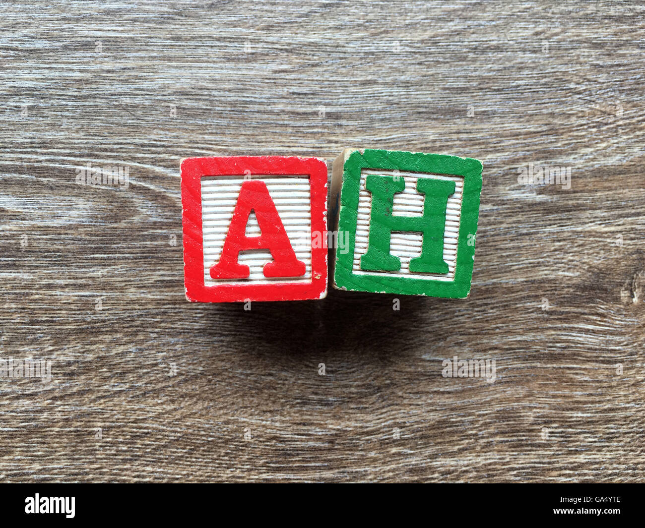 Wort AH mit Spielzeug Holz-Block-Buchstaben auf einem Holzbrett getan Stockfoto