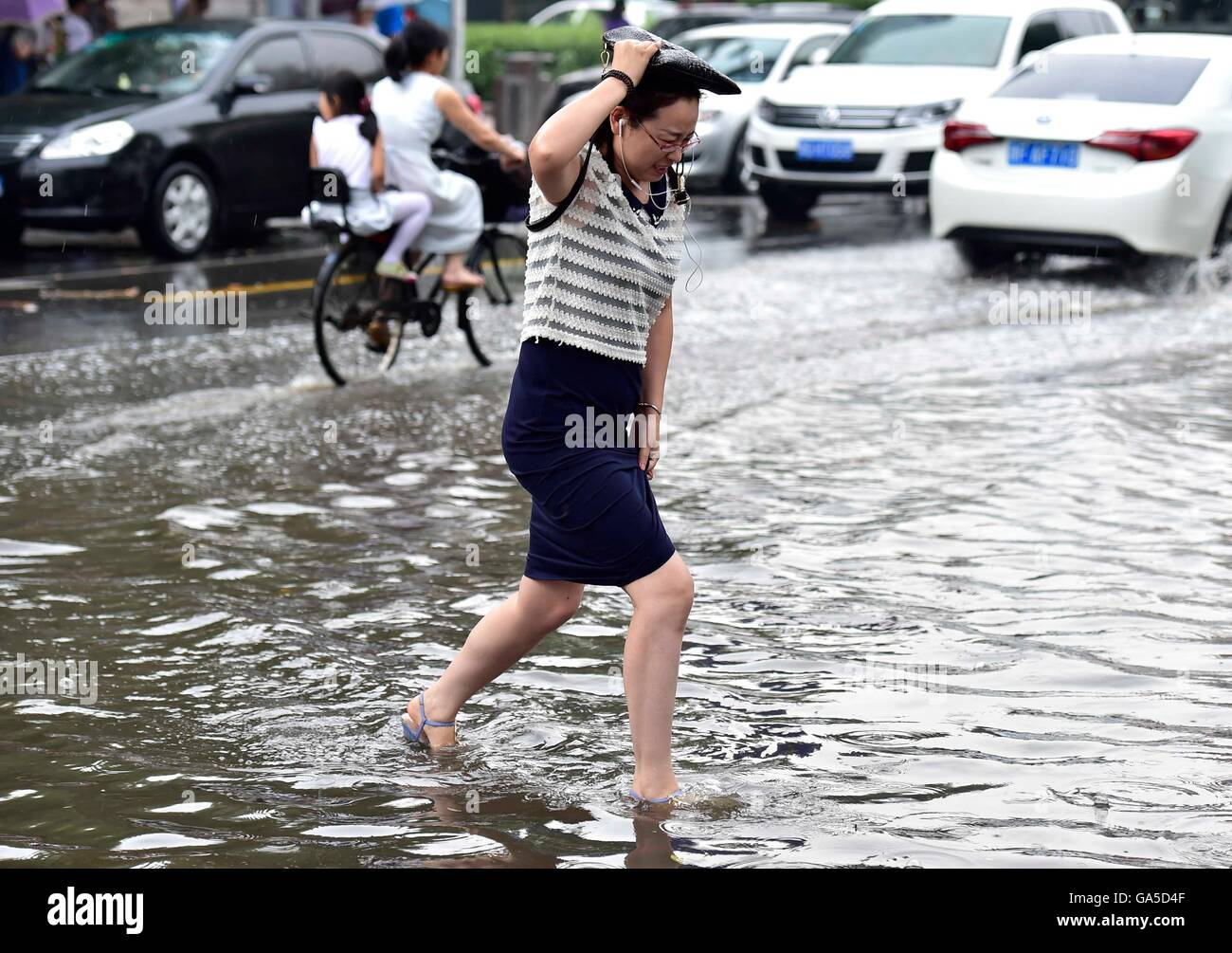 Tianjin, China. 3. Juli 2016. Ein Fußgänger geht über die aufgeweichten Straße in der Hexi District Tianjin, Nord-China, 3. Juli 2016. Regenstürme traf die Region Sonntag, Überschwemmungen Straßen und Verkehrsunterbrechungen verursachen. Bildnachweis: Yue Yuewei/Xinhua/Alamy Live-Nachrichten Stockfoto