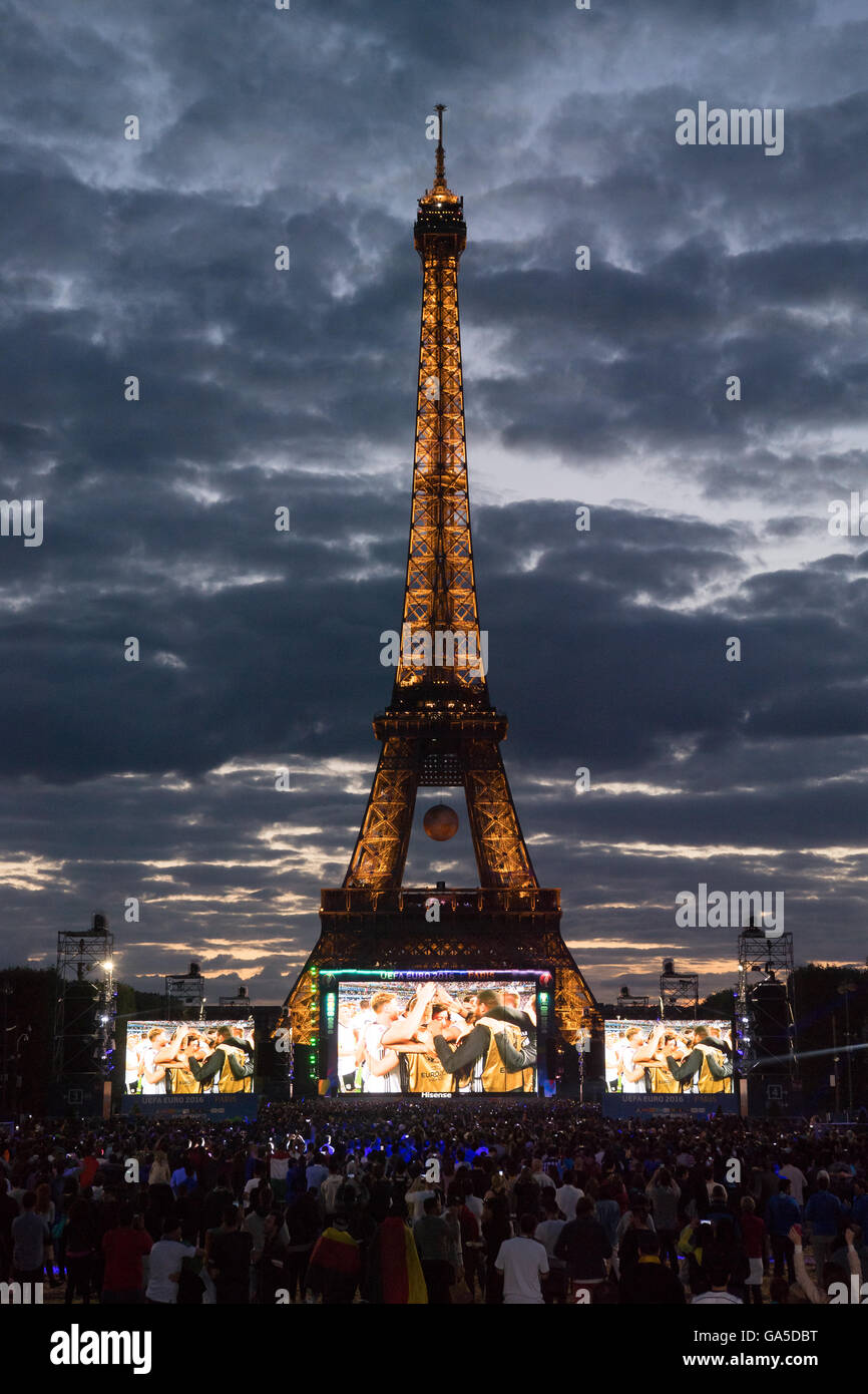 Italienische und deutsche Fußballfans beobachten die live-Übertragung des letzten Quartals entsprechen der Euro 2016 zwischen Deutschland und Italien in Bordeaux in einem Ventilator Masse Bereich vor dem Eiffel Turm in Paris, Frankreich 2. Juli 2016. Das Spiel wird auf mehreren Bildschirmen gezeigt von denen der größte 432 Quadratmeter (M misst). Foto: Peter Kneffel/dpa Stockfoto