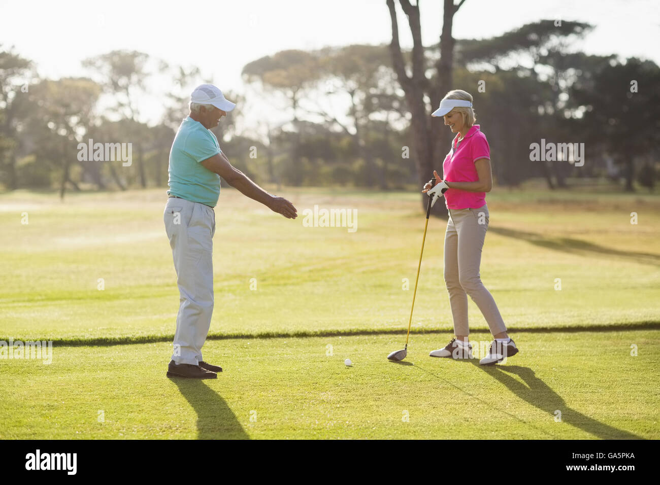 Seitenansicht des Reifen männlichen Golfspieler unterrichten Frau Stockfoto