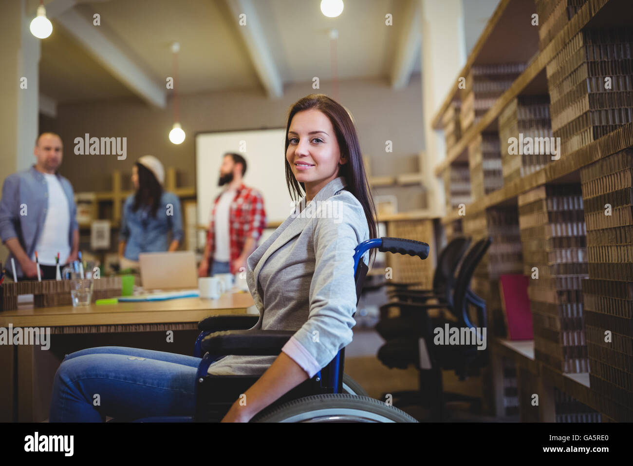 Geschäftsfrau auf Rollstuhl vom Schreibtisch Stockfoto