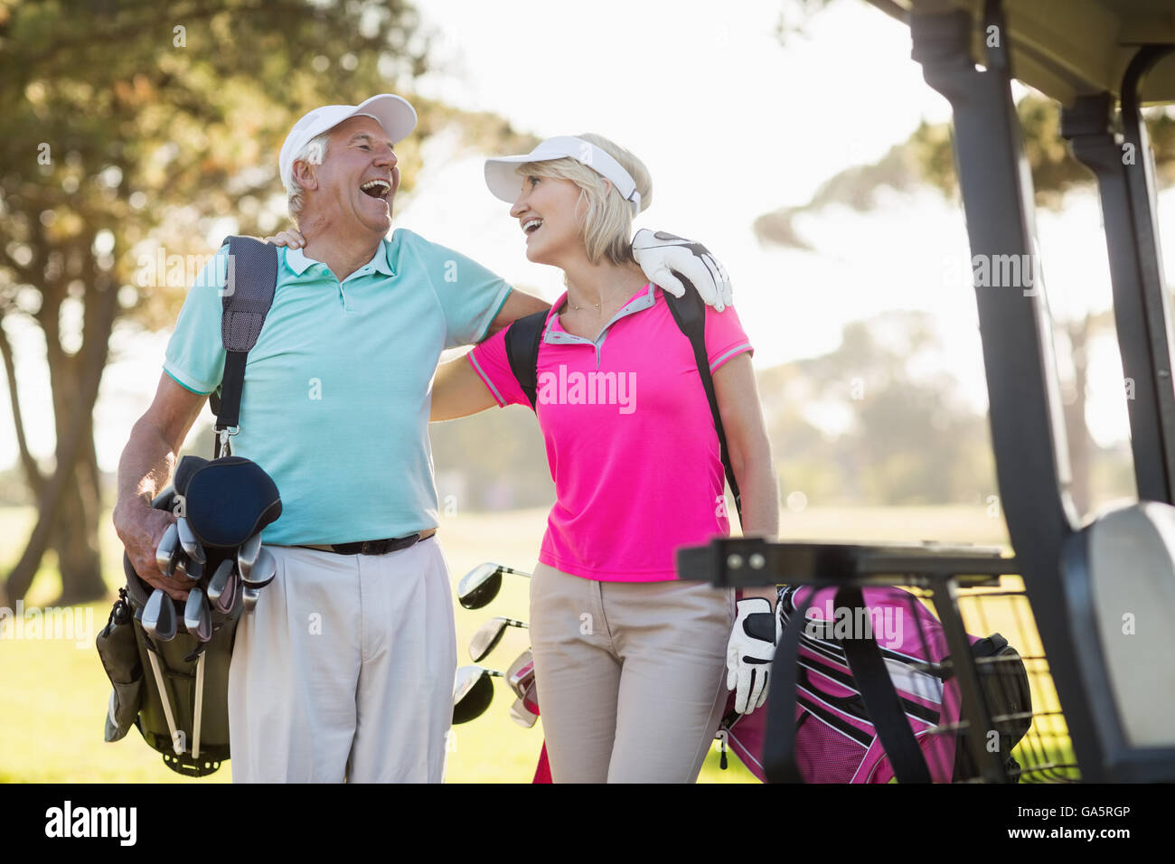 Fröhliche ältere Golfer paar mit Arm um Stockfoto