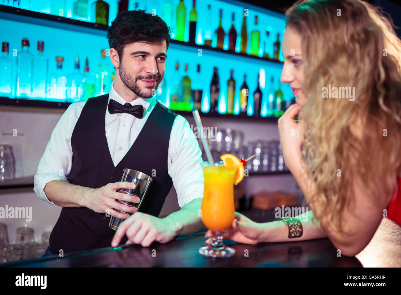 Gut aussehend Barkeeper flirten mit jungen Frau Stockfoto