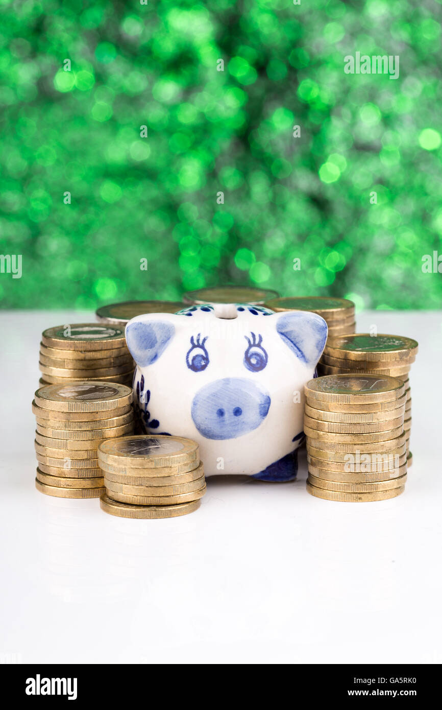Sparschwein mit einem Stapel von Münzen und einem unscharfen Hintergrund Stockfoto