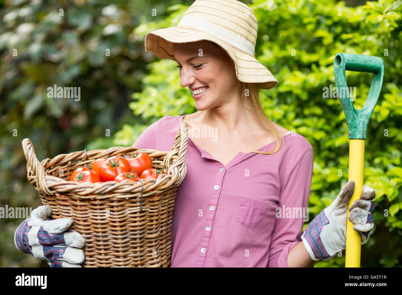 Glücklich Gärtner halten Tomate Korb und Arbeit-Werkzeugs Stockfoto