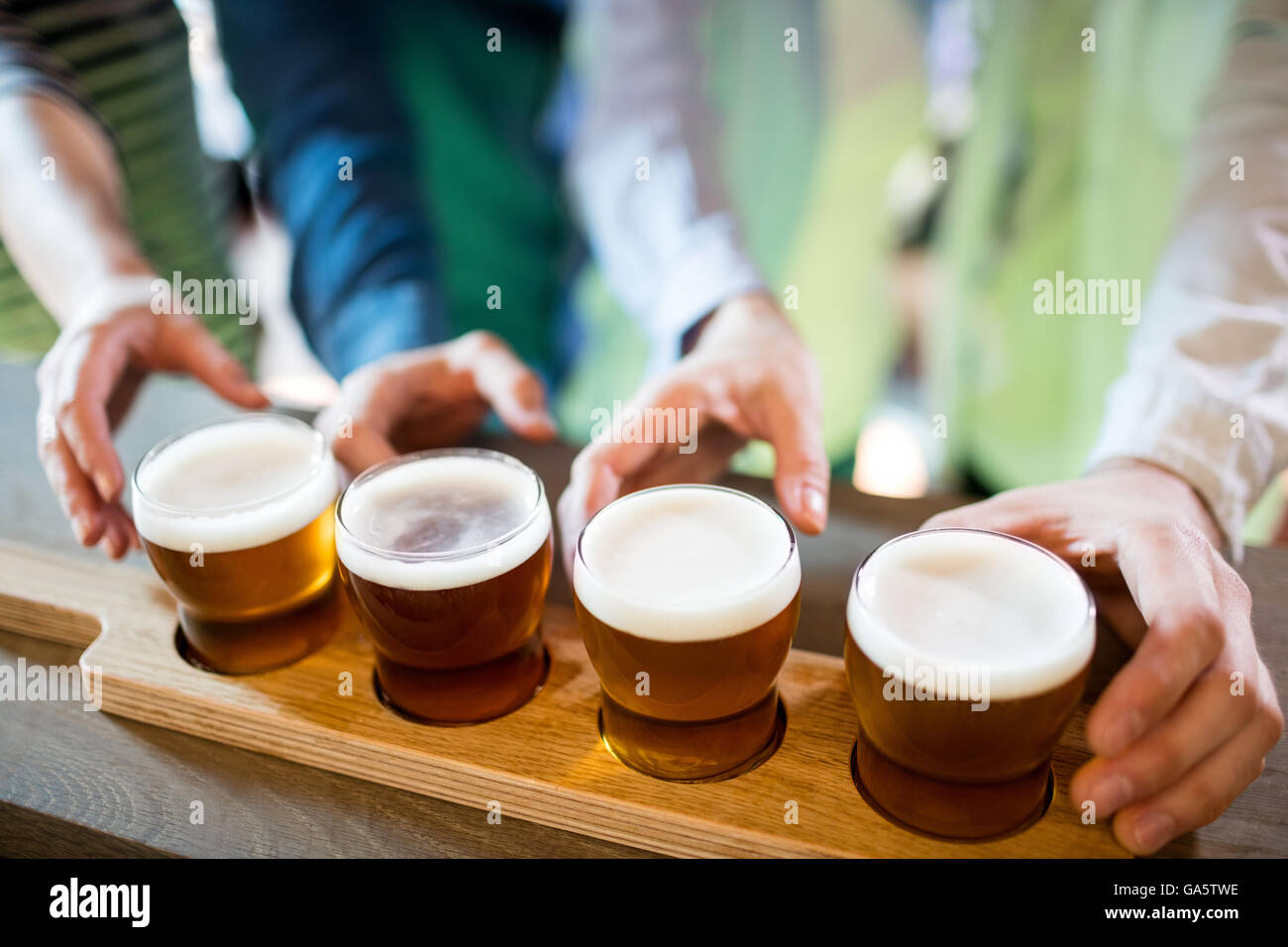 Freunde erreichen nach Bier Sampler auf Theke Stockfoto