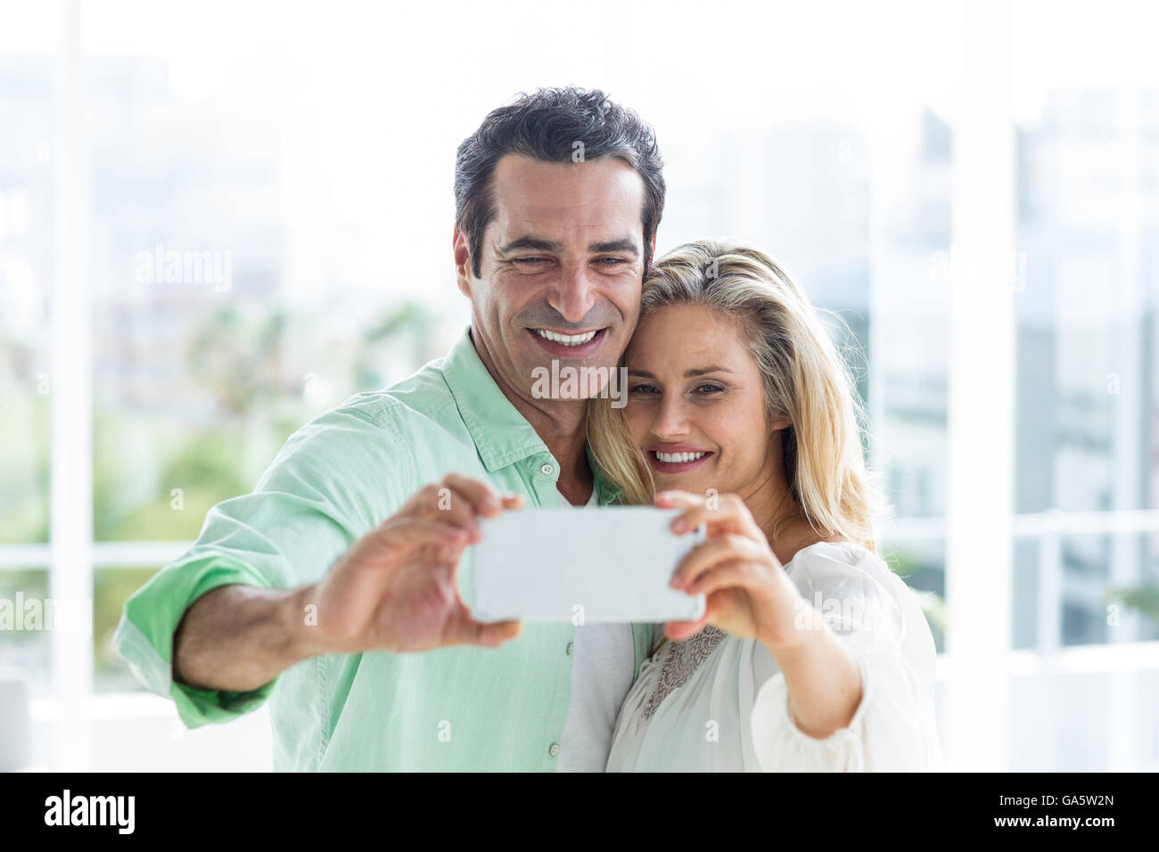 Mitte erwachsenes paar nehmen Selfie zu Hause Stockfoto