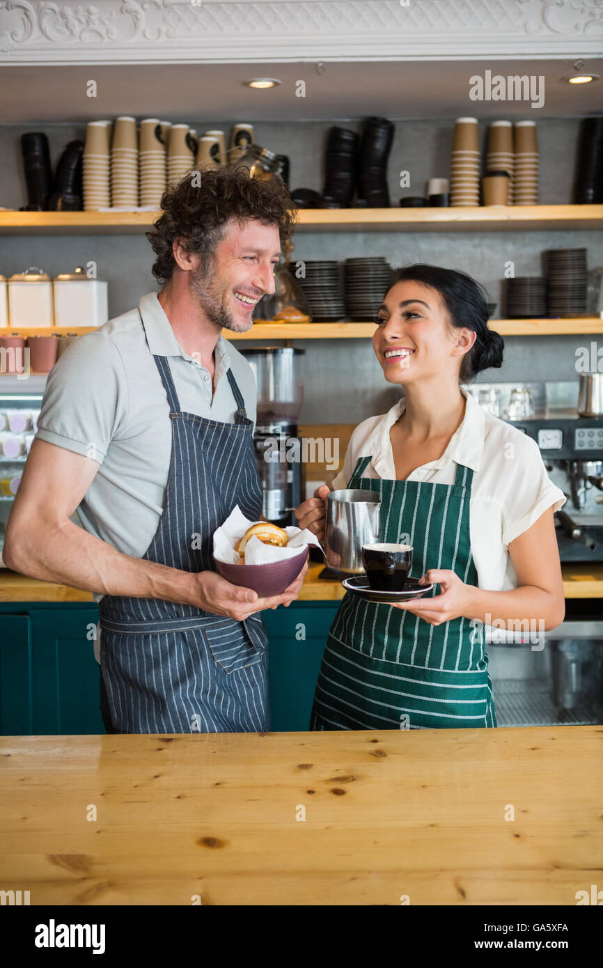 Kellner und Kellnerin hält Schüssel mit Snack und Kaffee Tasse Stockfoto