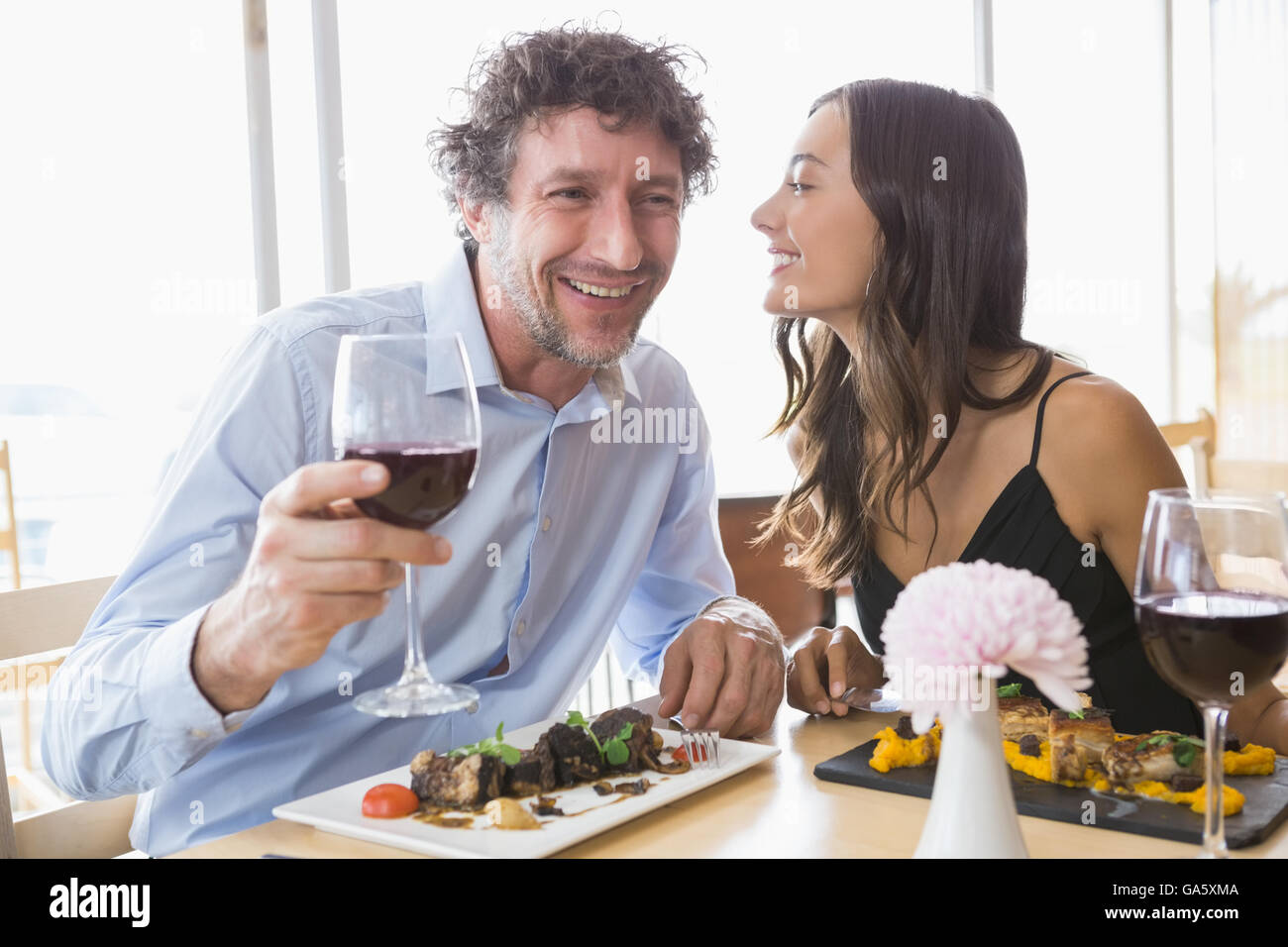 Frau auf Flüstern mans Ohr Stockfoto