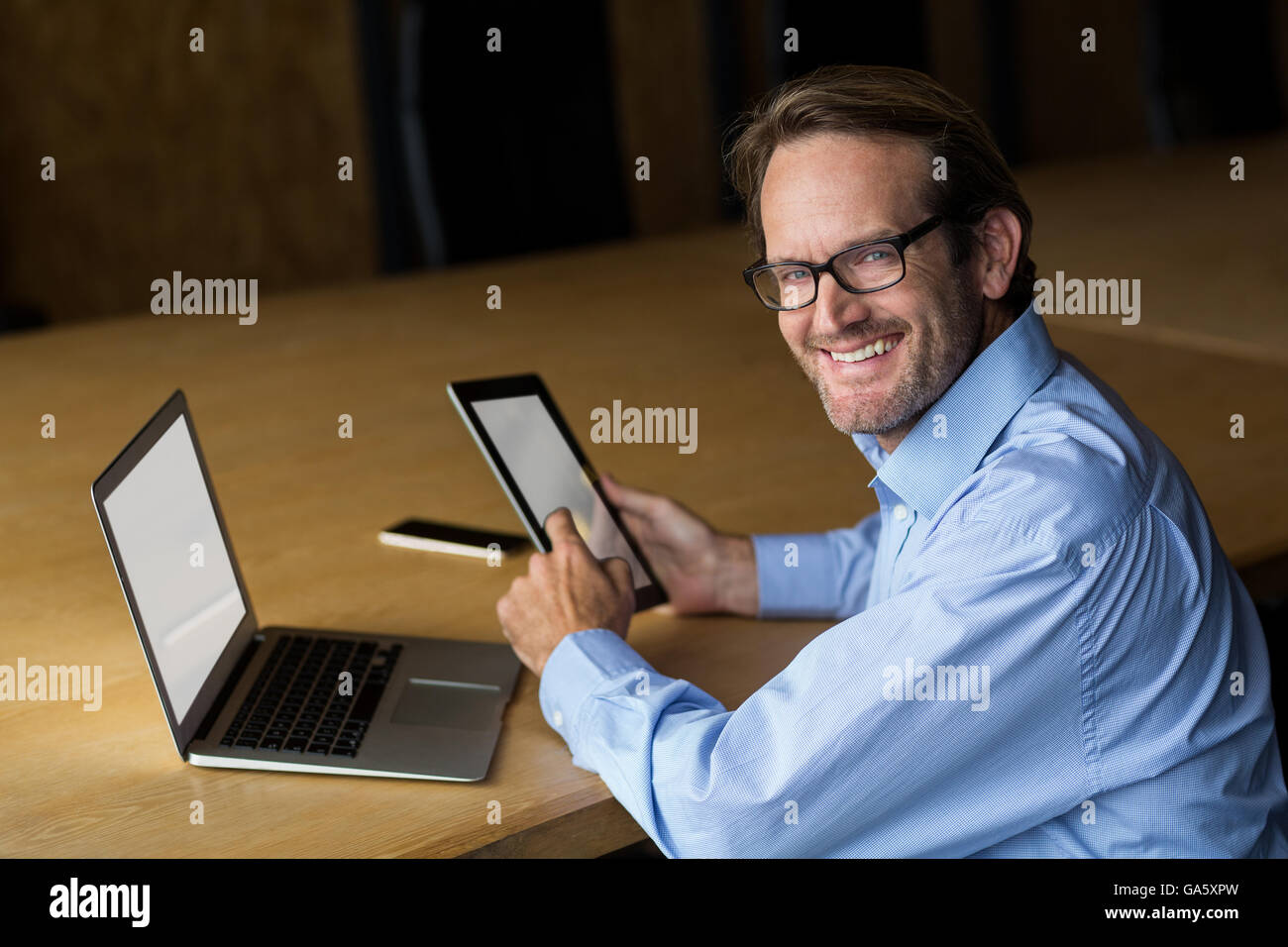 Porträt von lächelnden Mann hält digitale Tablet im Büro Stockfoto
