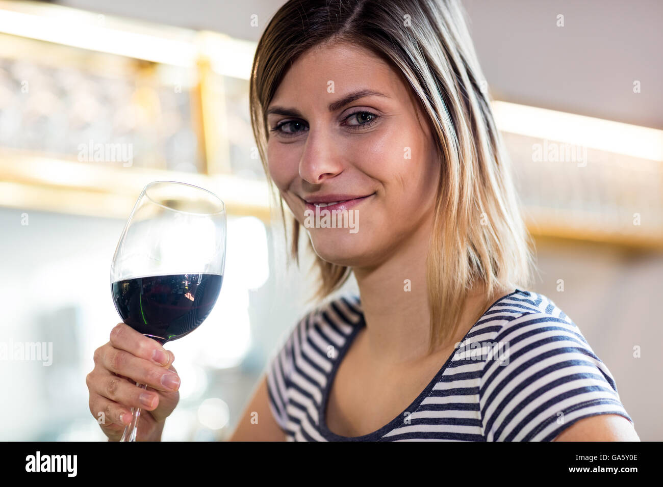 Schöne junge Frau, die Wein trinken Stockfoto