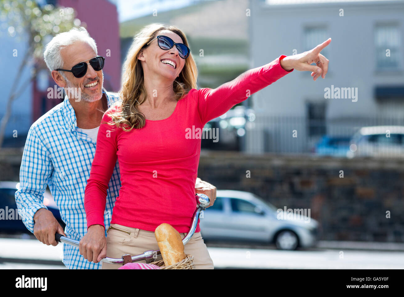 Glücklicher Mann mit Frau zeigt auf Stadtstraße Stockfoto