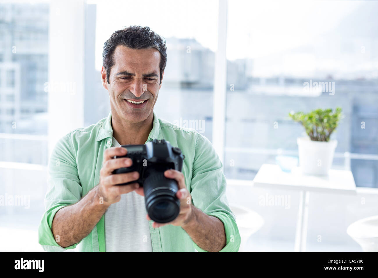 Mann, die Kamera zu halten, während Sie sitzen zu Hause Stockfoto