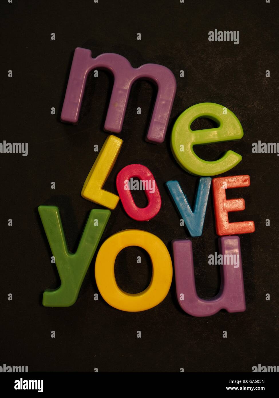 Du und ich, Liebe. Inspirierende Botschaft in lebhaften bunten Magneten Buchstaben auf schwarzem Hintergrund Stockfoto