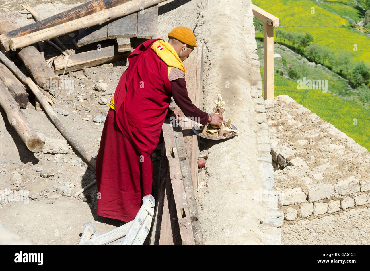 Mönch bietet Nahrung für Vögel bei Lamayuru Gompa, in der Nähe von Leh, Leh, Srinagar Straße, Ladakh, Jammu und Kaschmir, Indien. Stockfoto