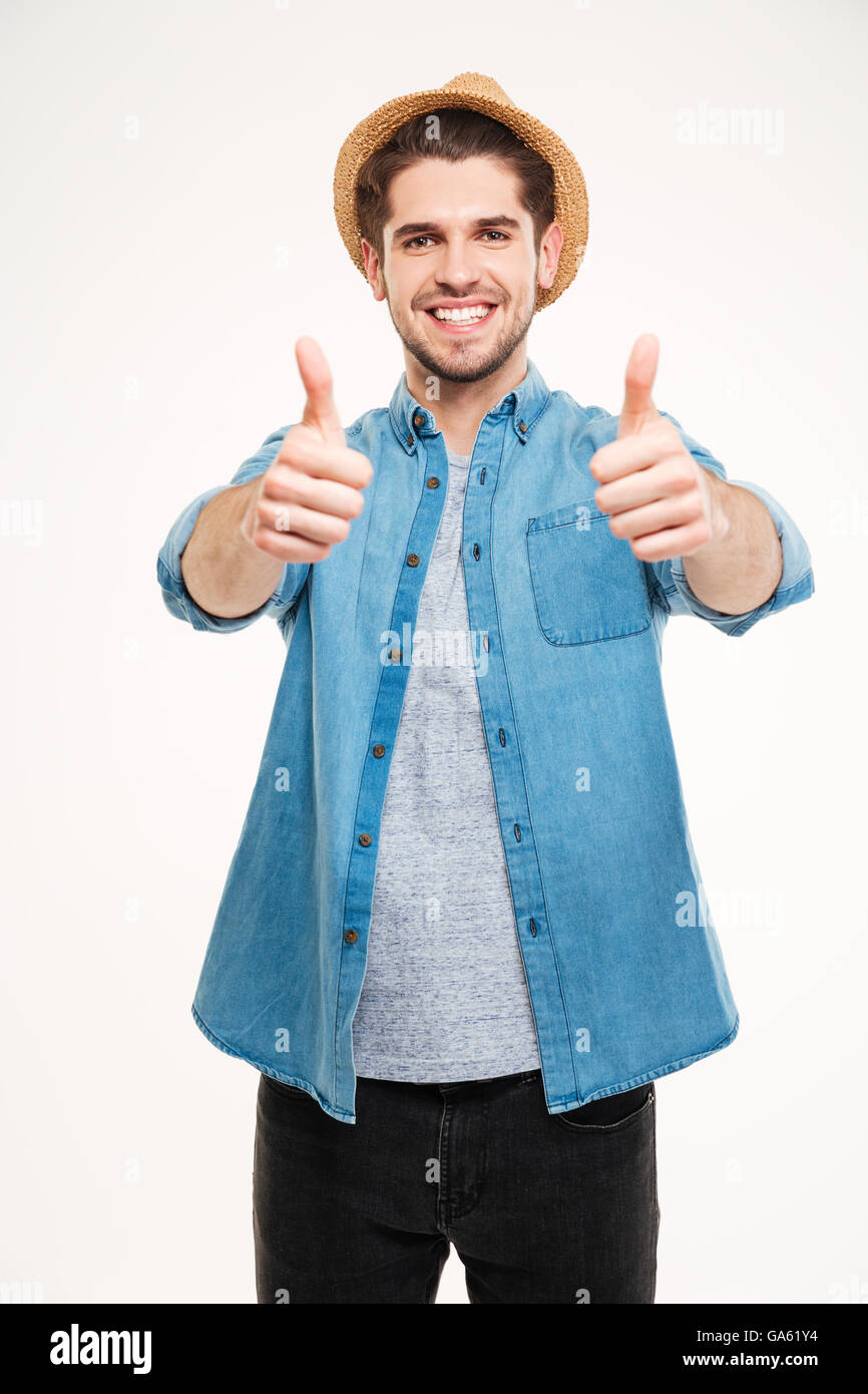 Fröhlichen junger Mann Daumen auftauchend isoliert auf weißem Hintergrund Stockfoto