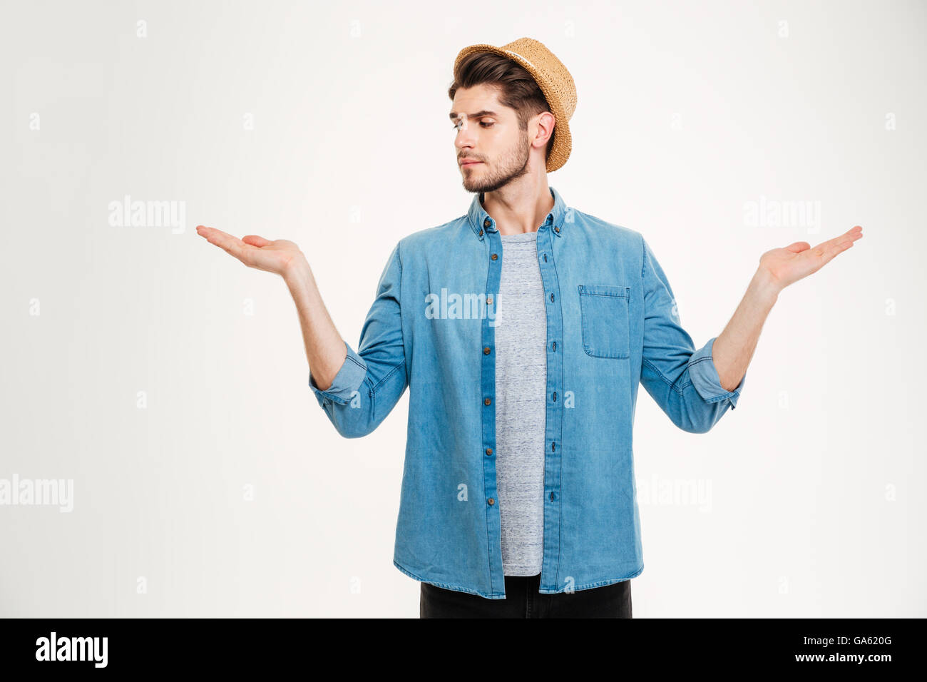 Hübscher junger Mann stehen und halten Exemplar auf beiden Handflächen auf weißem Hintergrund Stockfoto