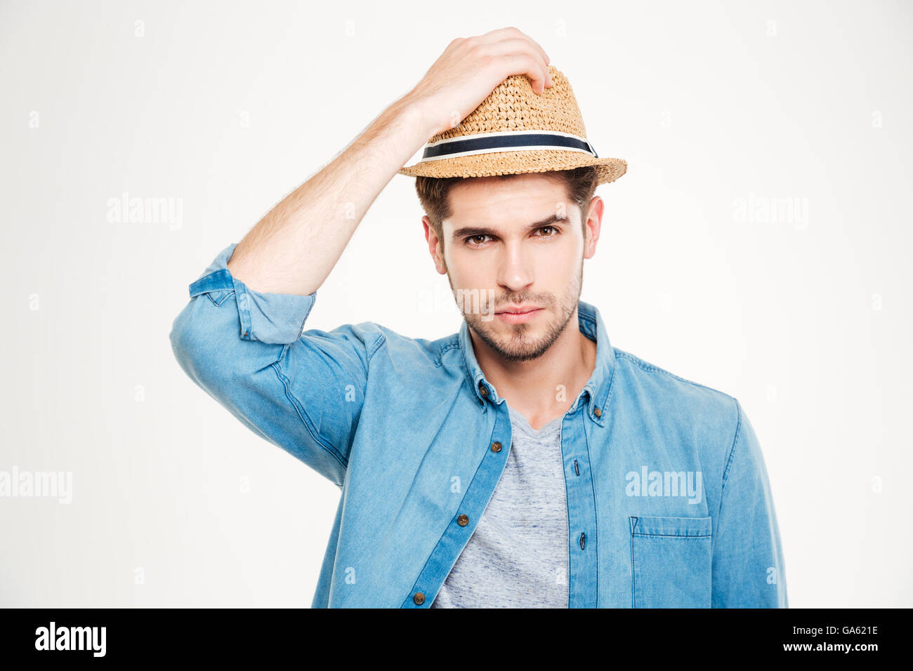 Porträt von attraktiven Borsten junger Mann im blauen Hemd und Hut auf weißem Hintergrund Stockfoto