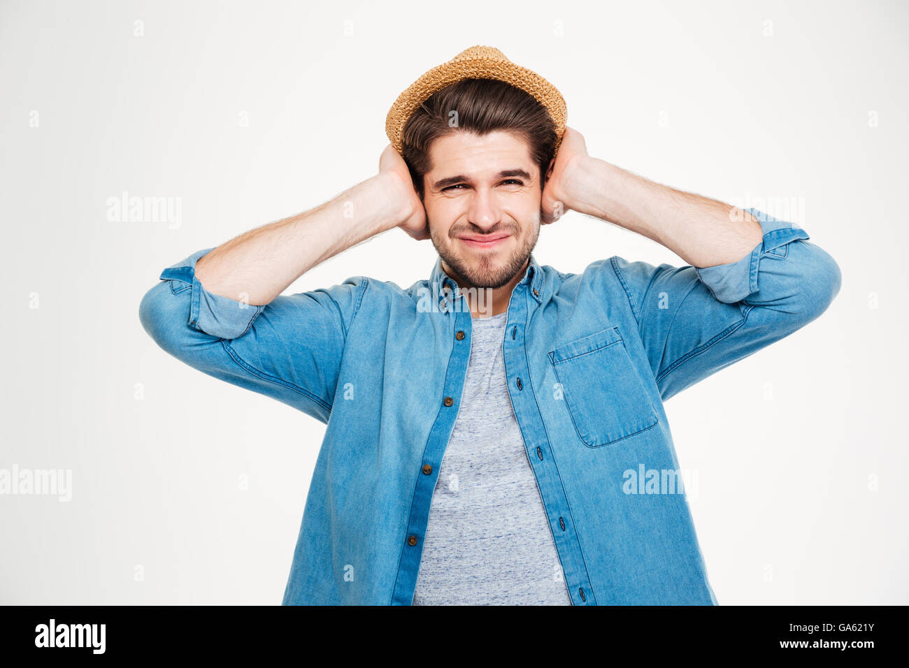 Hübscher Junge runzelte die Stirn fallenden Mann Ohren Hände auf weißem Hintergrund Stockfoto