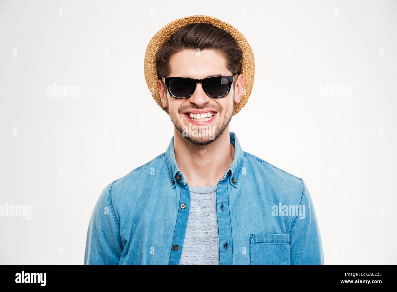 Nahaufnahme von fröhlichen jungen Mann in Hut und eine Sonnenbrille stehen und Lächeln auf weißem Hintergrund Stockfoto