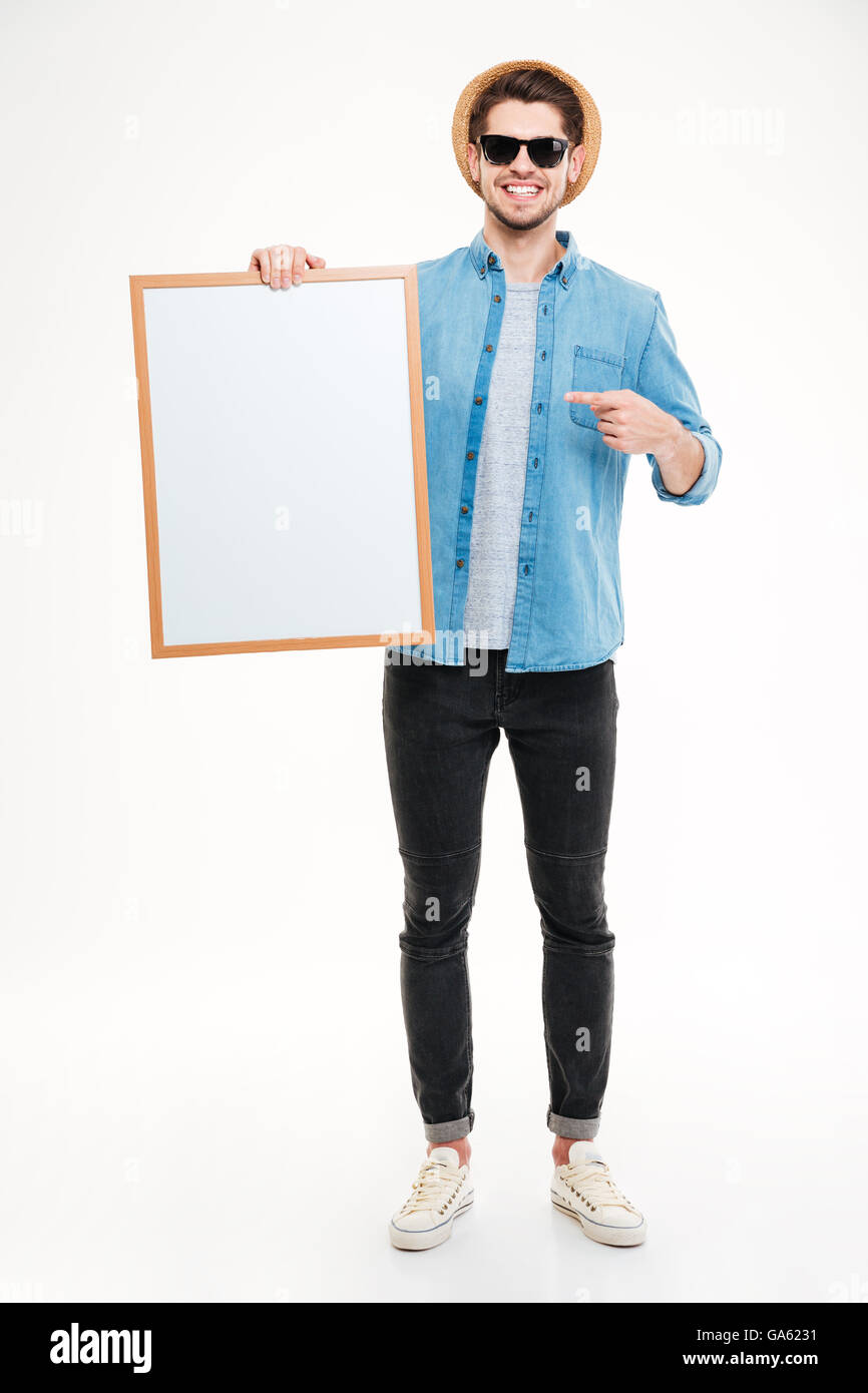 Glücklichen hübscher junger Mann hält leeres Whiteboard und zeigen es auf weißem Hintergrund Stockfoto