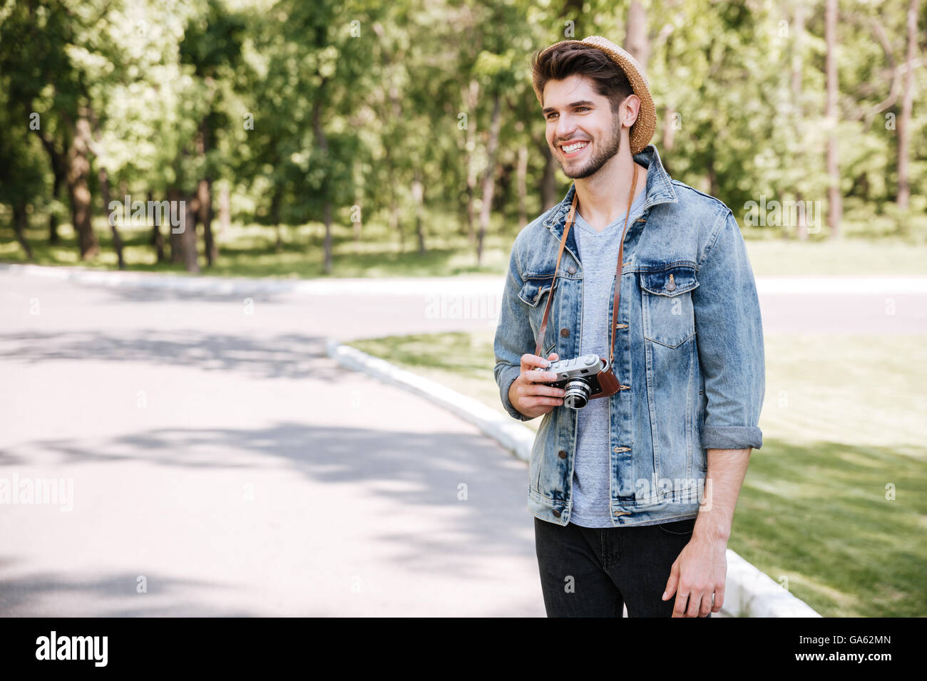 Glücklich schönen jungen Mann mit Hut mit alten Vintage Foto-Kamera im freien Stockfoto