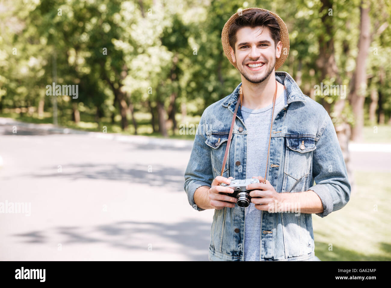 Glücklich schönen jungen Mann mit Hut mit alten Vintage Foto-Kamera im freien Stockfoto