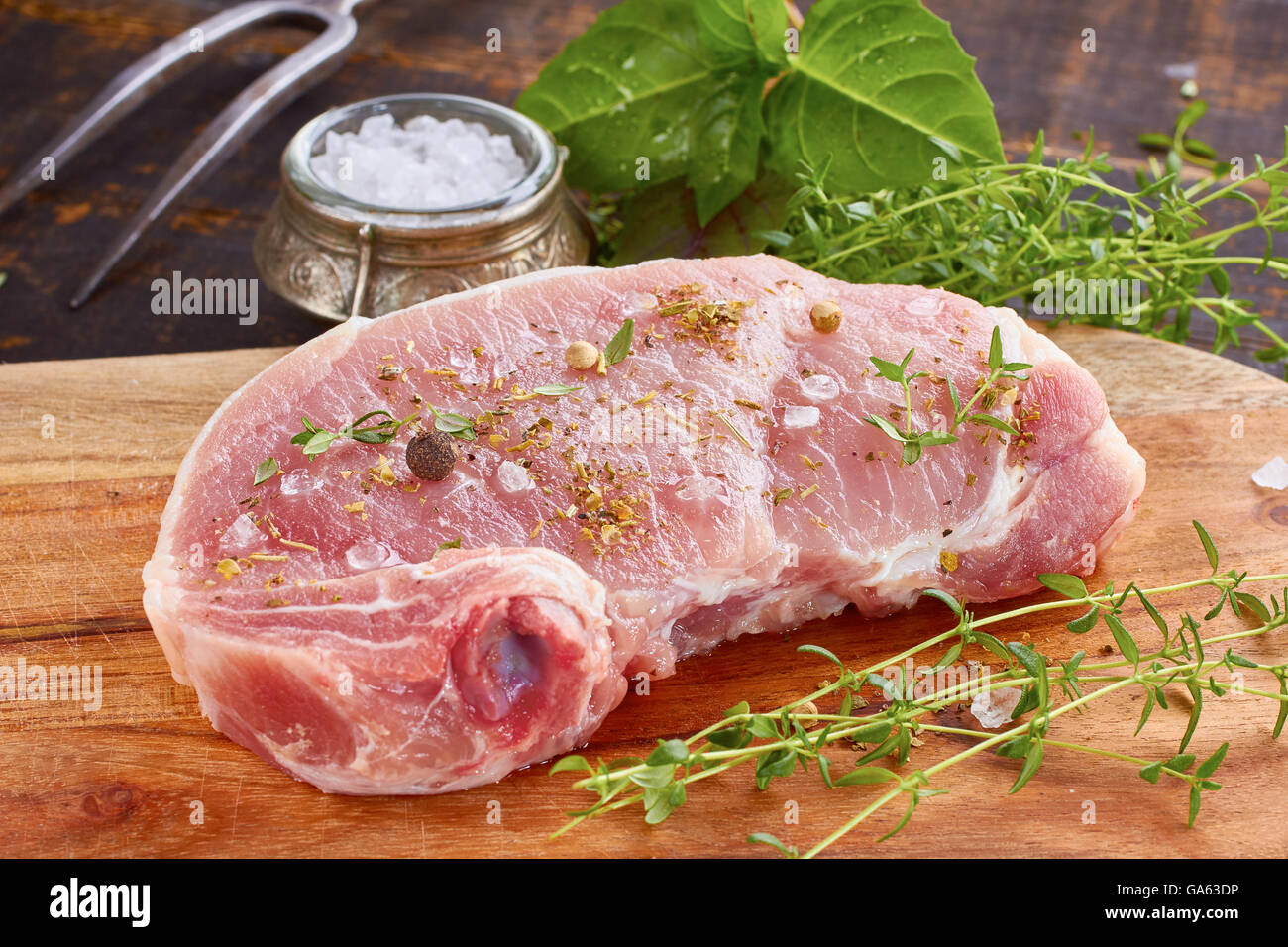 Rohes Schweinefleisch mit Gewürzen und Kräutern Stockfoto