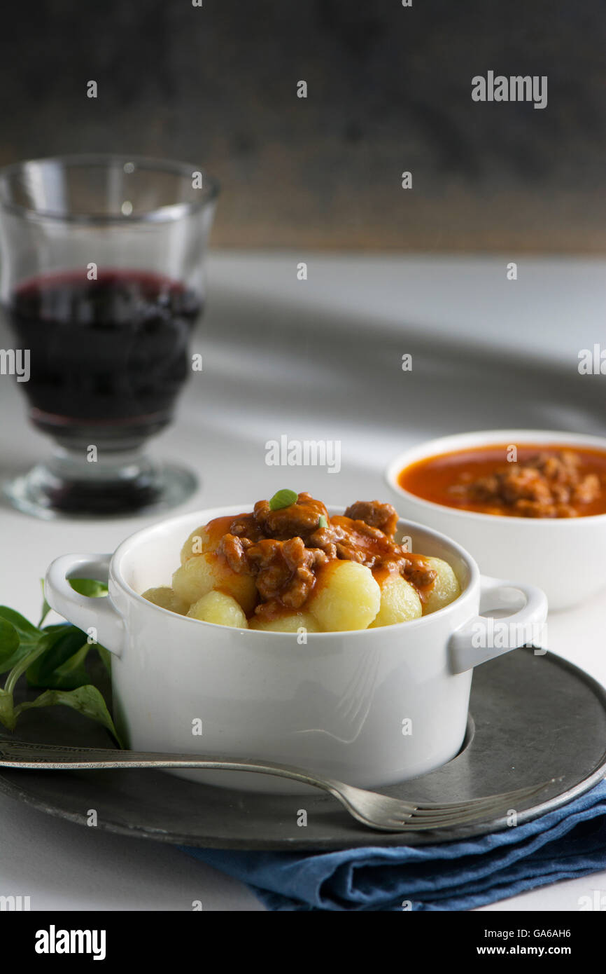 traditionelle hausgemachte Kartoffel-Gnocchi mit Tomatenmark und geriebenen Parmesan in Schüssel weiß Stockfoto