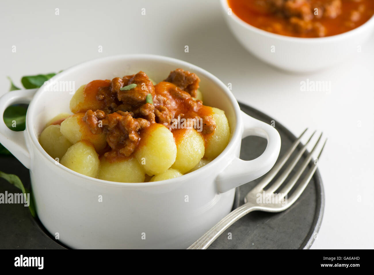 traditionelle hausgemachte Kartoffel-Gnocchi mit Tomatenmark und geriebenen Parmesan in Schüssel weiß Stockfoto