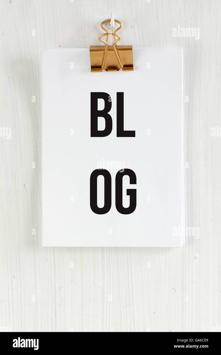 Blog-Zwischenablage, konzeptionelle Kommunikation. auf weißen hölzernen Hintergrund und golden Clip. Stockfoto