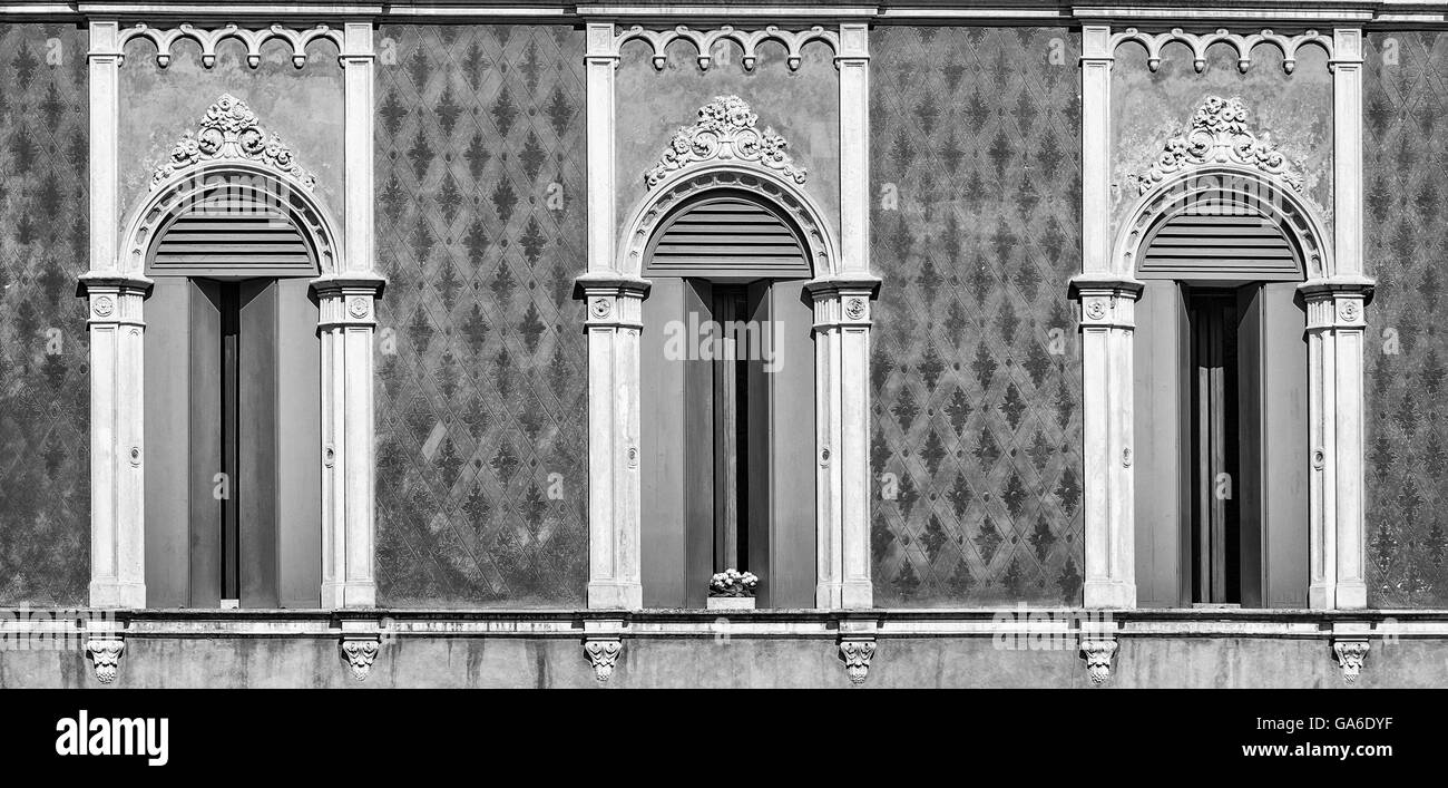 Drei Fenster im Stil der venezianischen Gotik eines alten italienischen Palazzos. Stockfoto