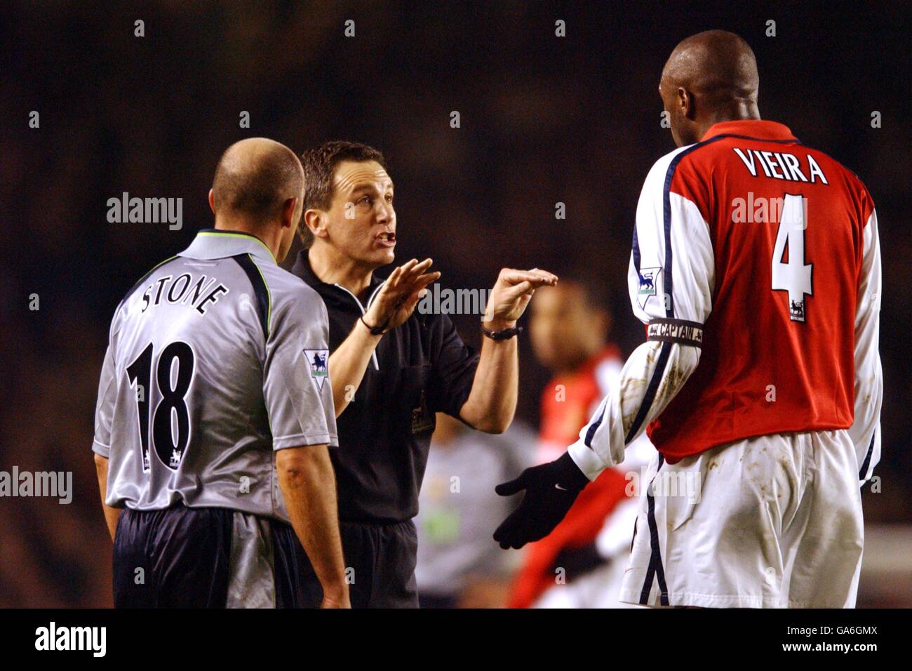 Schiedsrichter Alan Wiley (c) hält Arsenals Patrick Vieira (r) und Steve Stone von Aston Villa (l) Stockfoto