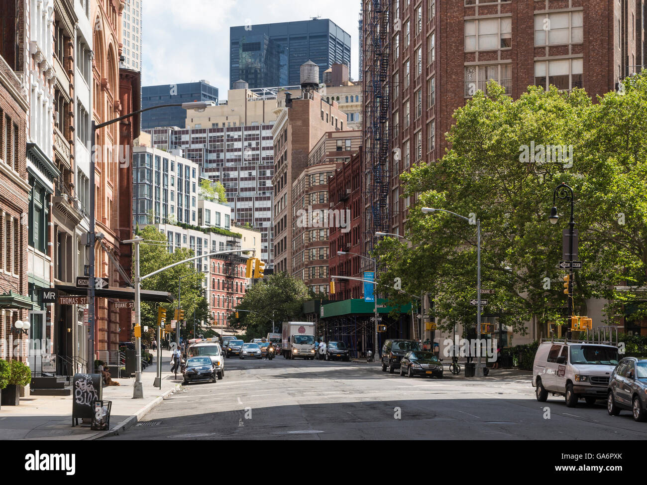 Blick auf die Straße entlang der Hudson Street, Tribeca, mit kontrastierenden alte und neue Gebäude und Wolkenkratzer mit Feuerleitern Stockfoto