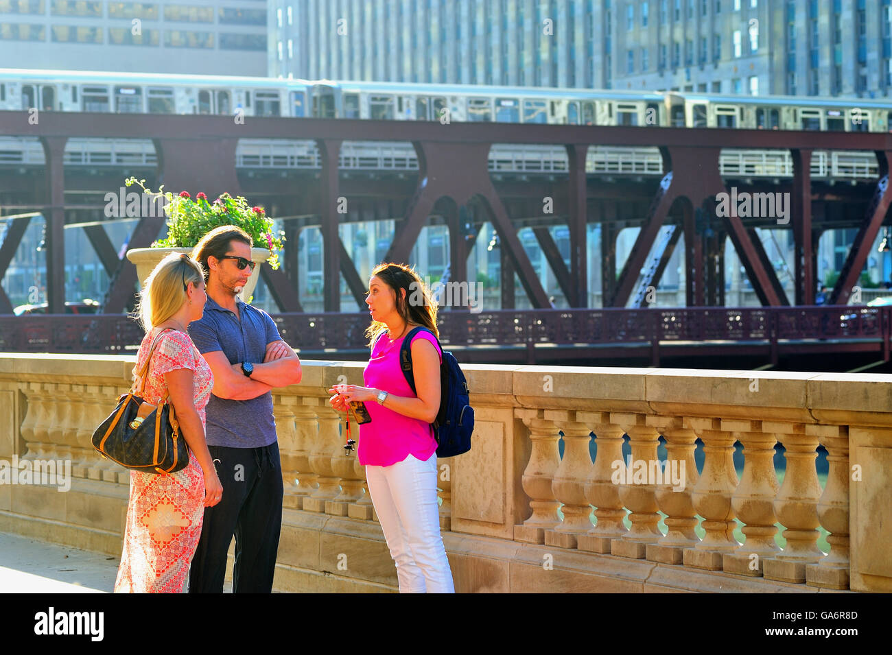 Menschen Pause für ein beiläufiges Gespräch nach dem Treffen an der South Bank der Chicago River bei einem sommerlichen Abend. . Chicago, Illinois, USA Stockfoto